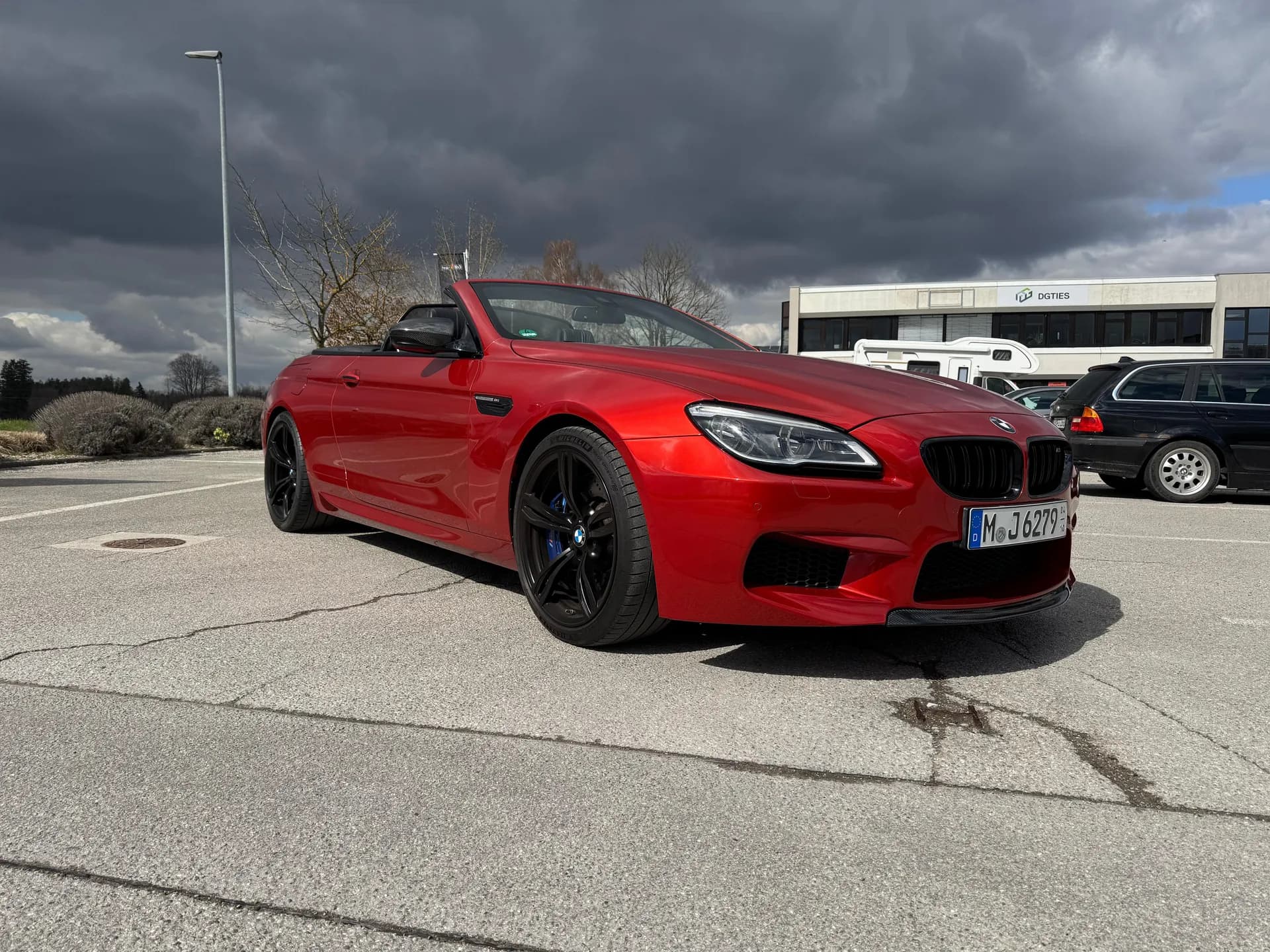 Rotes BMW M6 Cabrio auf dem Hof vor der Werkstatt