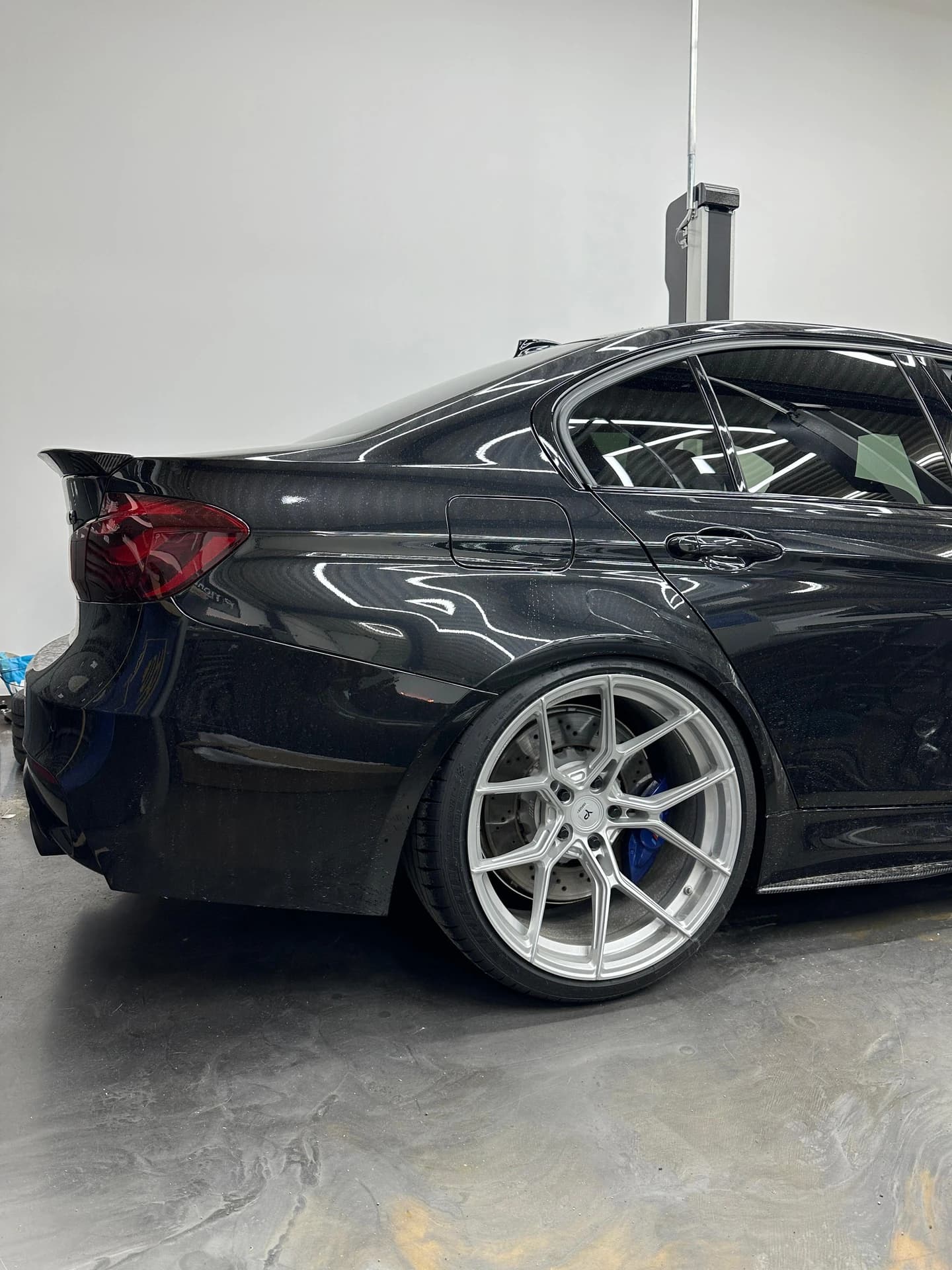 Schwarzer BMW M3 mit silbernen Schmiedefelgen und blauen Bremssätteln